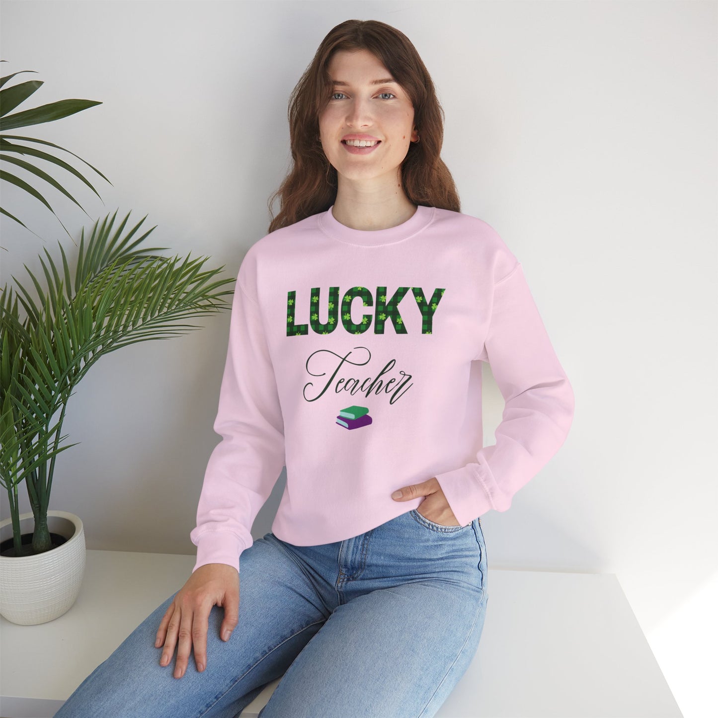 Model wearing Lucky Teacher sweatshirt with green clover lettering and book icon.
