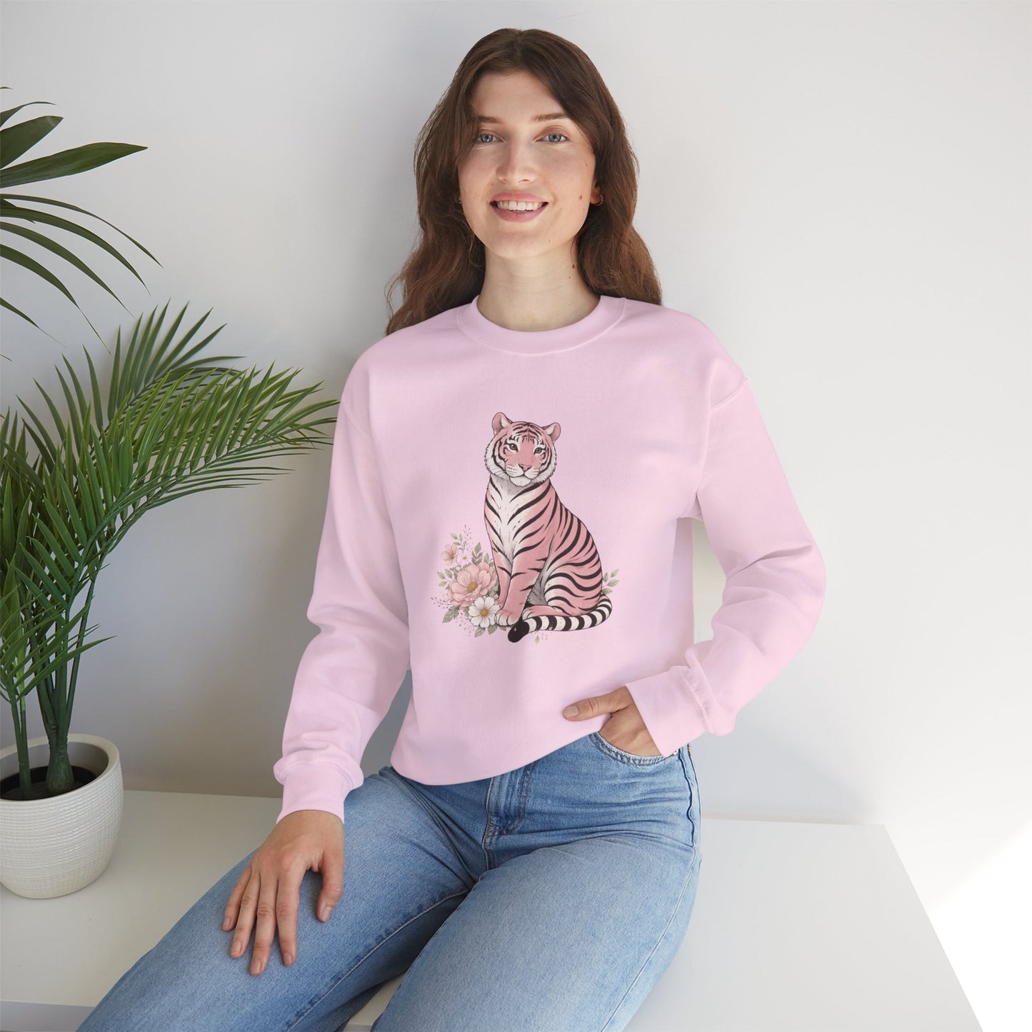 A cozy unisex sweatshirt featuring a pink tiger sitting among pastel flowers