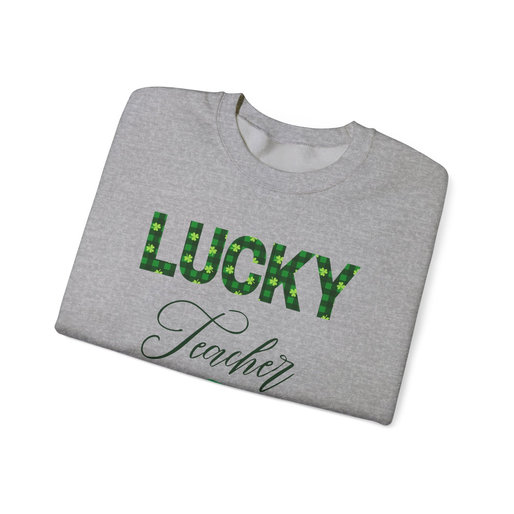 Folded Lucky Teacher sweatshirt with green clover lettering and book icon.
