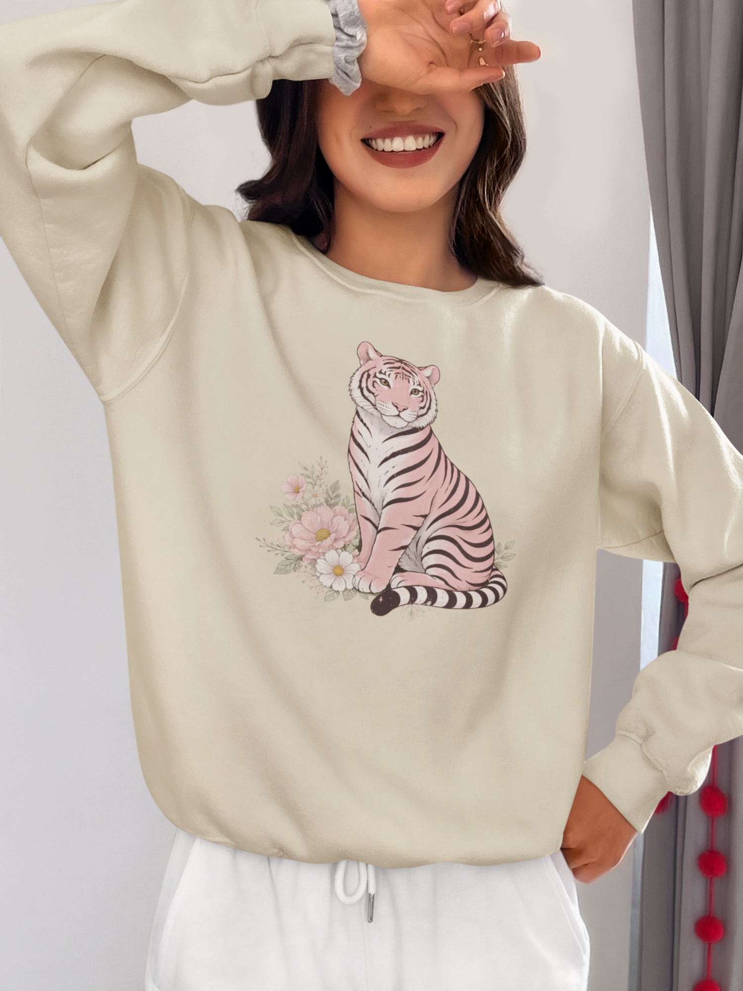 A cozy unisex sweatshirt featuring a pink tiger sitting among pastel flowers
