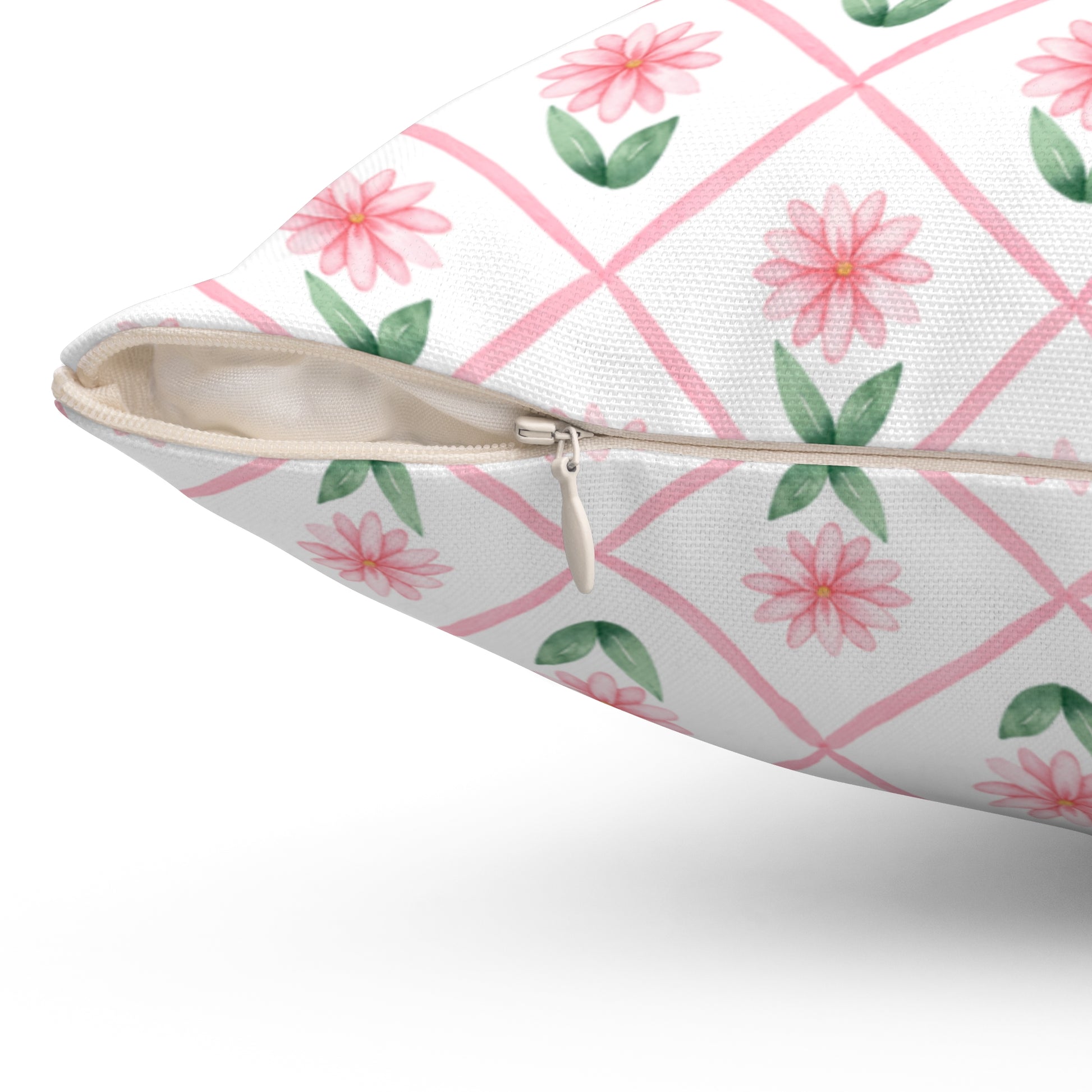 A close-up view of a pink daisy lattice throw pillow showing the beige zipper and textured fabric on the cover.