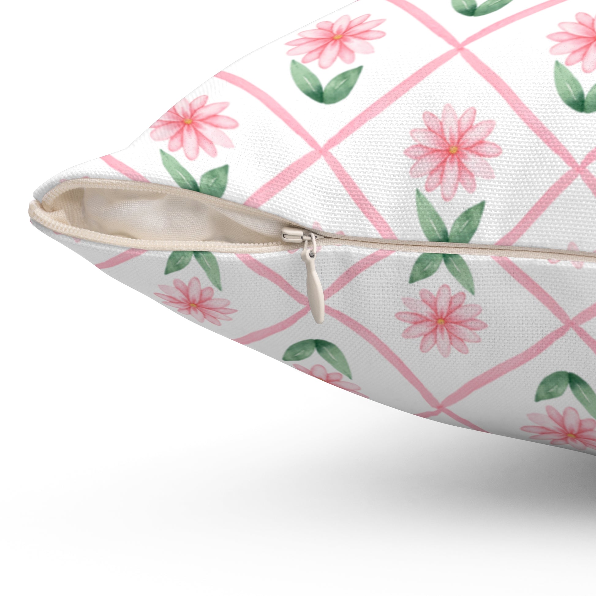 A close-up view of a pink daisy lattice throw pillow showing the beige zipper and textured fabric on the cover.