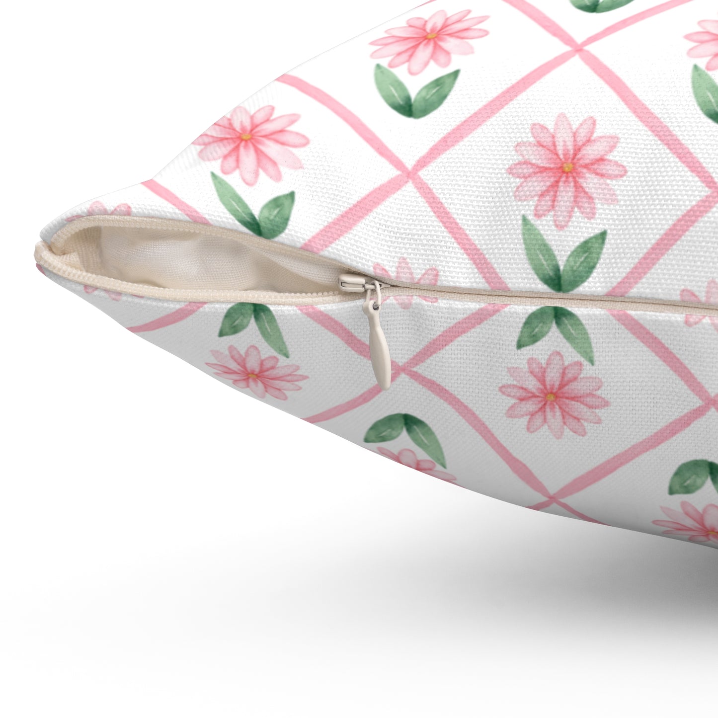 A close-up view of a pink daisy lattice throw pillow showing the beige zipper and textured fabric on the cover.