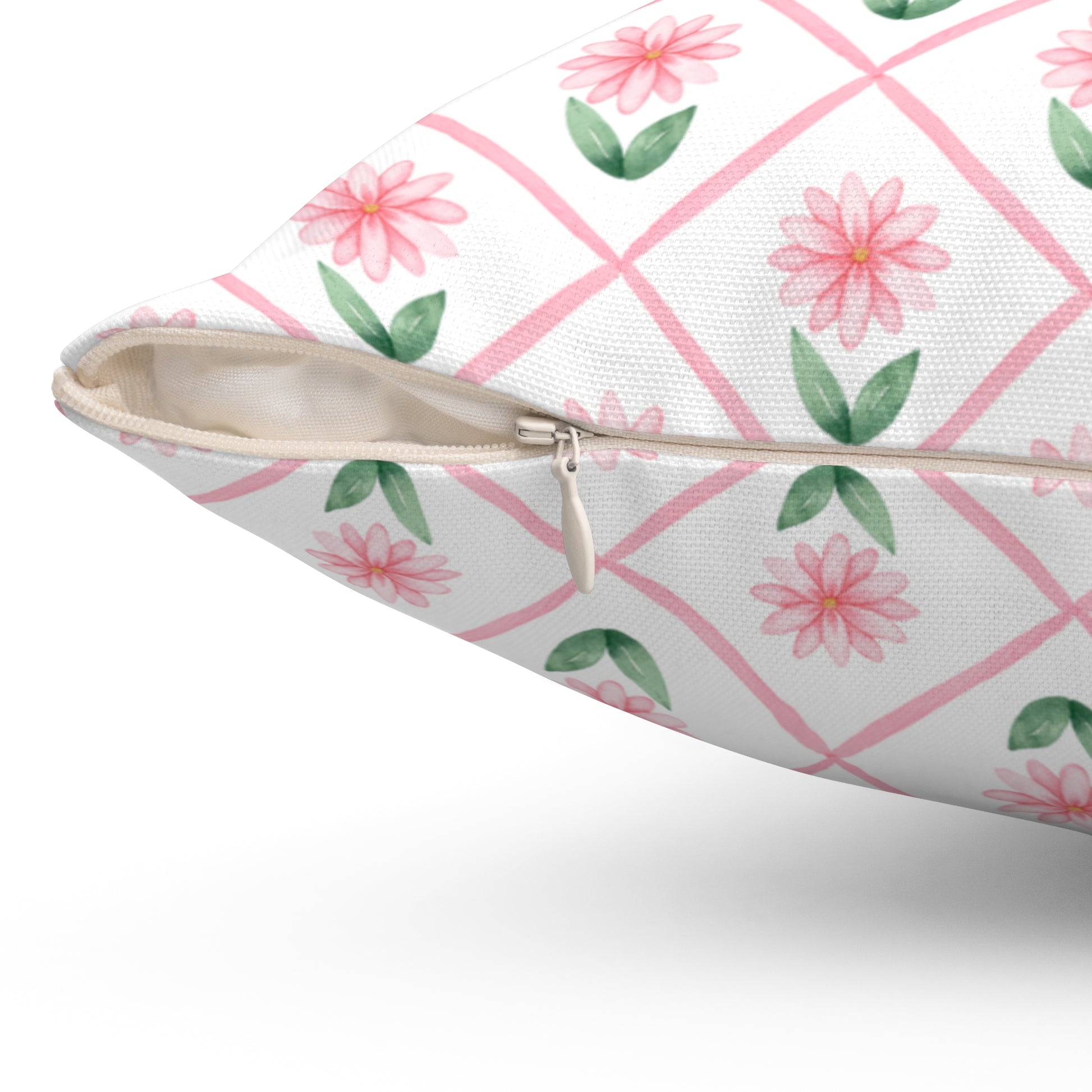 A close-up view of a pink daisy lattice throw pillow showing the beige zipper and textured fabric on the cover.